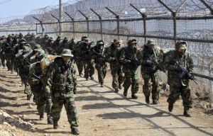 South Korean marine soldiers walk along an iron fence after crossing the river near the tense border with North Korea during a cross-country drill in Gimpo, 30 km northwest of Seoul, on February 25, 2011. The drill comes ahead of a massive annual joint exercise by South Korean and US troops which will begin on February 28. AFP PHOTO/JUNG YEON-JE (Photo credit should read JUNG YEON-JE/AFP/Getty Images)